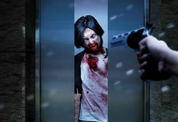手拿枪指着电梯里的僵尸万圣节的概念 — 图库照片