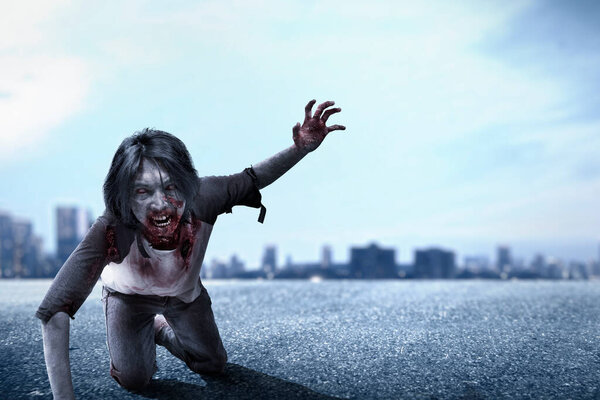 Scary zombie with blood and wound on his body crawling on the city