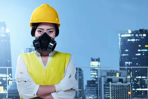 Asian construction worker with hardhat and safety mask standing with crossed arms. Happy Labor Day