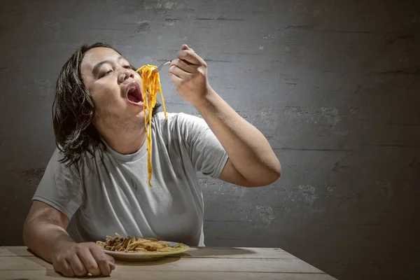 家庭でスパゲッティを食べるアジア人男性 ジャンクフードのコンセプト — ストック写真