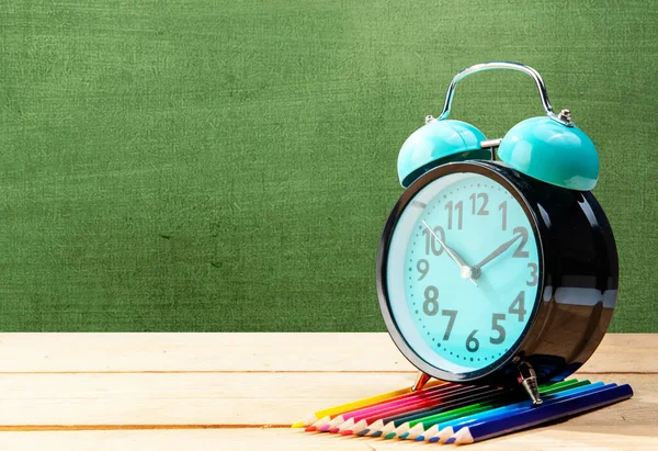 Escritorio Con Reloj Fila Lápices Colores Con Fondo Pizarra Concepto —  Fotos de Stock