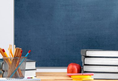 Kitap ve karatahta zeminli kırtasiye masası. Okul konseptine dönüş