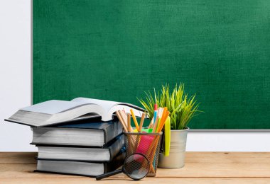 Kitap ve karatahta zeminli kırtasiye masası. Okul konseptine dönüş