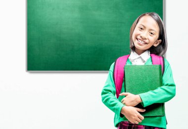 Sınıfta kitap ve sırt çantalı Asyalı küçük bir kız var. Okul konseptine dönüş