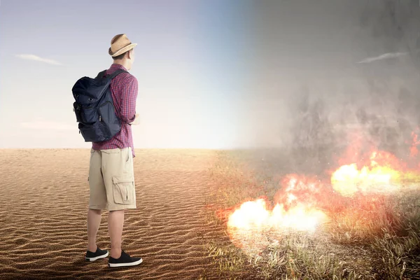 Asiatischer Mann Mit Rucksack Blickt Auf Brennenden Boden Auf Dem — Stockfoto
