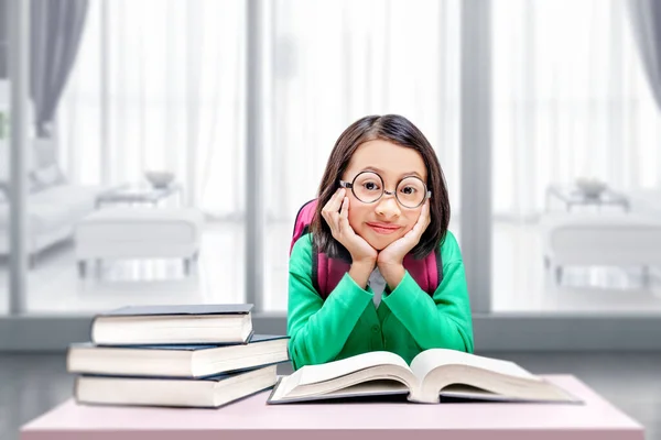 眼鏡をかけたアジア系の少女が本を読んでいる 学校のコンセプトに戻る — ストック写真