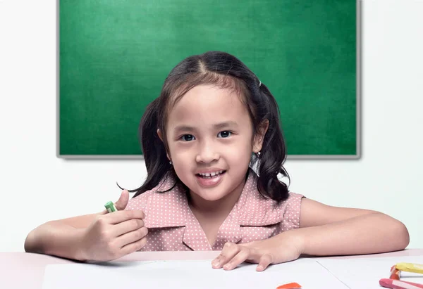 テーブルの上の紙にクレヨンの絵を描いたアジア系の少女 学校のコンセプトに戻る — ストック写真
