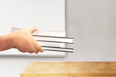 Elleri beyaz tahta arka planda bir yığın kitap tutuyor. Okul konseptine dönüş