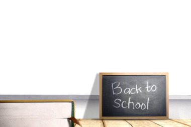 Masanın üzerinde okula dönüş metninin yazılı olduğu küçük bir tahta.