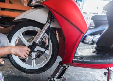 Motosiklet tamircisi atölyede motosiklet tamir ediyor.