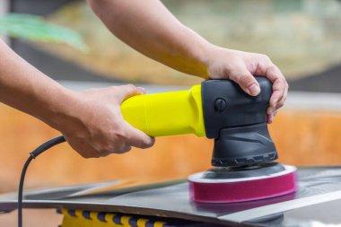 Cilalama makinesi olan, araba cilalayan adam.