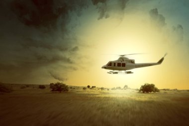 Arka planda bulutlu bir manzaraya sahip havada uçan bir helikopter.