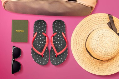 Pasaport, terlik, şapka, güneş gözlüğü ve renkli arka planı olan valiz çantası. Dünya Turizm Günü