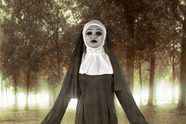 可怕的魔鬼修女站在闹鬼的森林上 — 图库照片