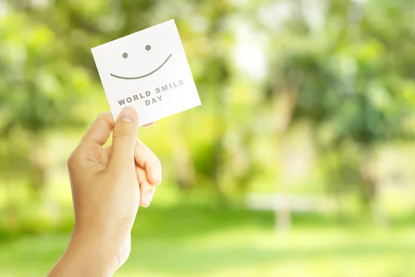 Hand Hålla Papper Med World Smile Day Meddelande Världsleendagen — Stockfoto