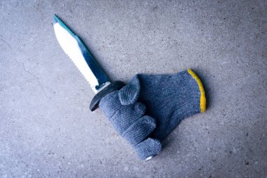 Yerde bıçak tutan işçiye güvenlik eldiveni.
