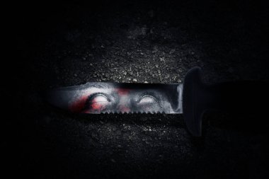 Bıçağında zombi gölgesi olan kanlı bir bıçak. Cadılar Bayramı konsepti