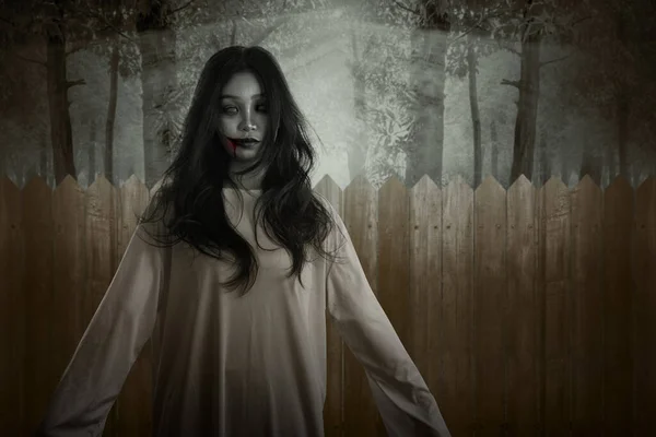 Skrämmande Spökkvinna Som Står Med Ett Trästaket Skogsbakgrund Halloween Konceptet — Stockfoto