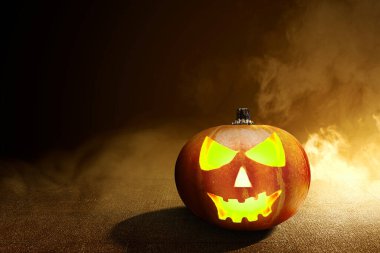 Beton zeminde Jack-o-Lantern dumanlı ve karanlık arka planda