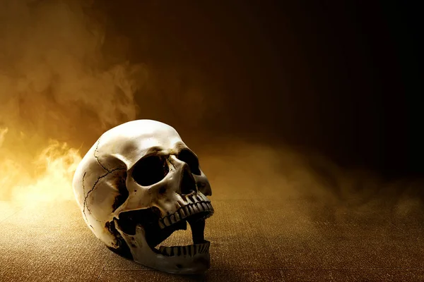 연기와 어두운 배경을 콘크리트 바닥에 인간의 두개골 — 스톡 사진