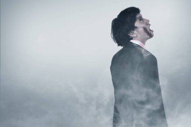 Vücudunda kan ve yara olan korkunç bir zombi siste duruyor.