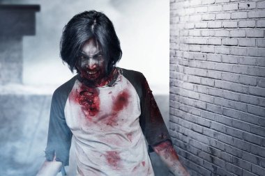 Vücudunda kan ve yara olan korkunç bir zombi terk edilmiş binada yürüyor.