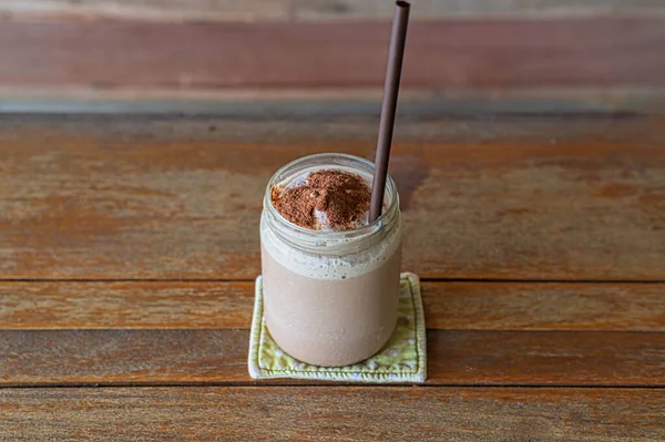 Delicious chocolate smoothie  in jars on wooden table — Stock Photo, Image