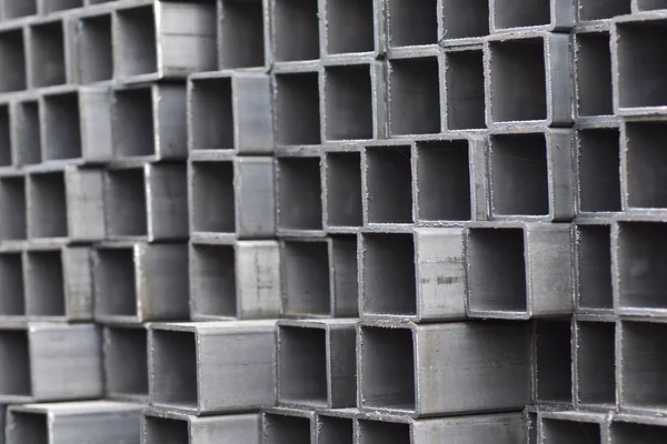 Metalowa rura profilowa o przekroju prostokątnym w opakowaniach w magazynie wyrobów metalowych — Zdjęcie stockowe