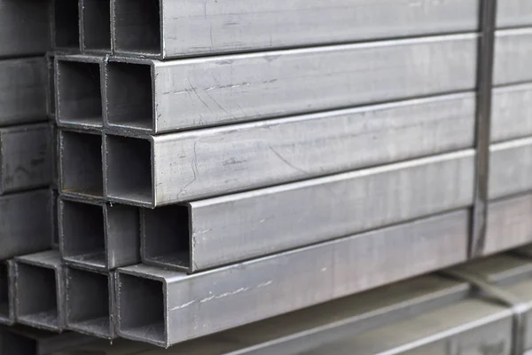 Metallprofilrör med rektangulärt tvärsnitt i förpackningar på lagret av metallprodukter Stockfoto