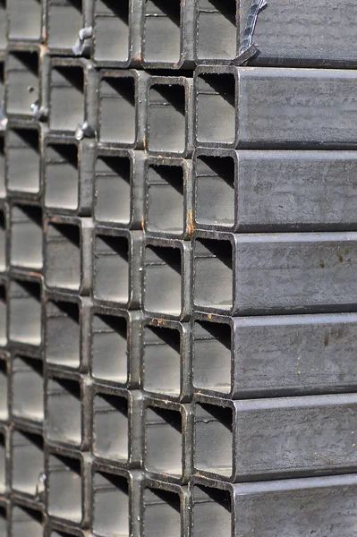 Metalowa rura profilowa o przekroju prostokątnym w opakowaniach w magazynie wyrobów metalowych — Zdjęcie stockowe