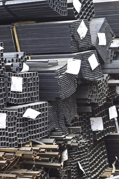 Perfiles metálicos de diferentes tipos se encuentran en el almacén de productos metálicos — Foto de Stock