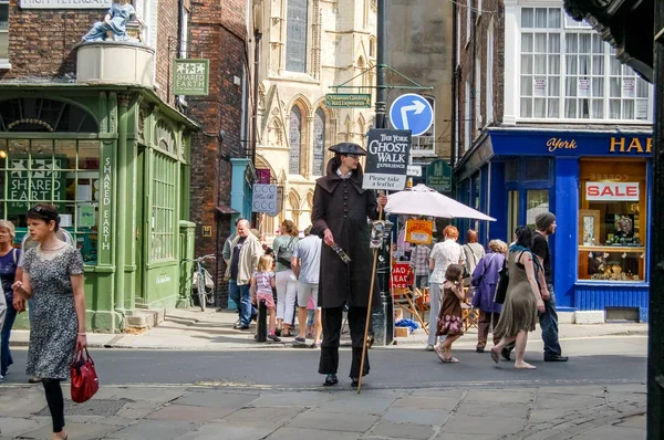 York, İngiltere, İngiltere - 05 Ağustos 2011: Bir adam York sokak tatil ile meşgul iken bu arka planda görülebilir York Minster Abbey yakınındaki şehir merkezinde bir popüler tatil olayı 'Hayalet yürümek' in reklam dönem kostüm giymiş 