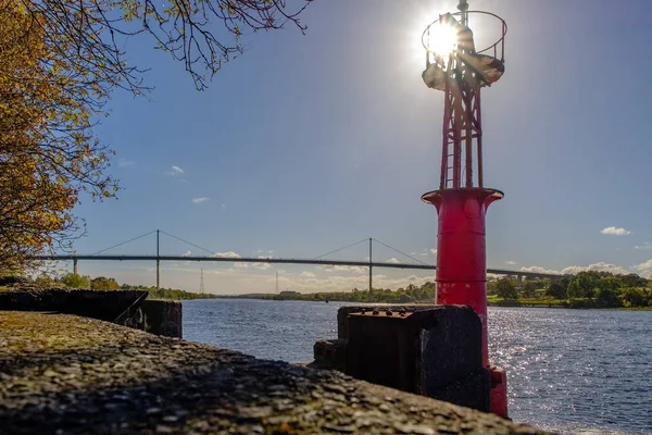 Old Port Beacon on the River Clyde with Erskine Bridge in the Background and the sun behind the Beacon.