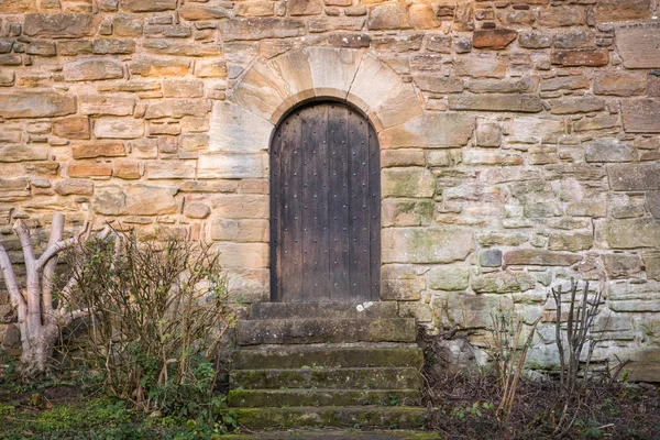 Ancient Scottish Castle Door with medieval arches and studded door panels.