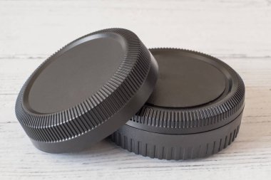 Beyaz boyalı ahşap yüzeyde kamera merceği kapakları ve gövde kapakları