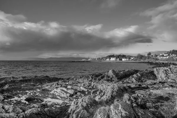 Une image en noir et blanc de Largs Looking over Lichen Covered Rocks — Photo