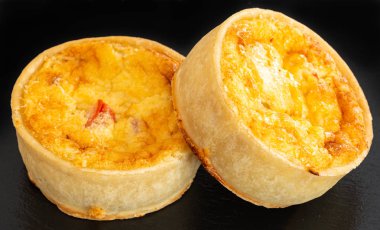 Küçük Bir Siyah Kayrak Tepsi üzerinde İki Küçük Taze Bakes Quiches.