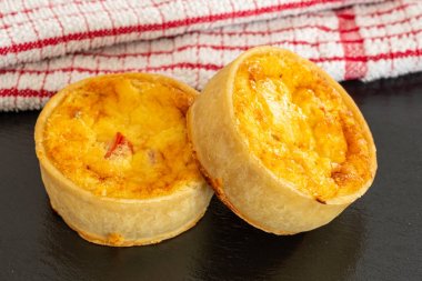 Küçük Bir Siyah Kayrak Tepsi üzerinde İki Küçük Taze Bakes Quiches.