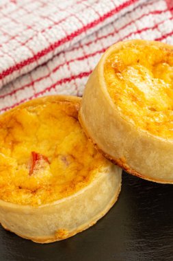 Küçük Bir Siyah Kayrak Tepsi üzerinde İki Küçük Taze Bakes Quiches.