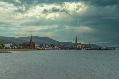 Largs, Scotlands Covid-19 pandemik tecrit aylarında güneye, kasaba merkezine doğru bakıyor. Ribbon yıldırımı ve gök gürültüsü şehre iniyor..