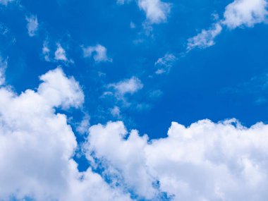 Parlak güneşli bir günde, geniş kabarık beyaz bulutlarla güzel, derin, mavi bir gökyüzü. Doğa ve hava kavramları için mükemmel bir bulut manzarası..