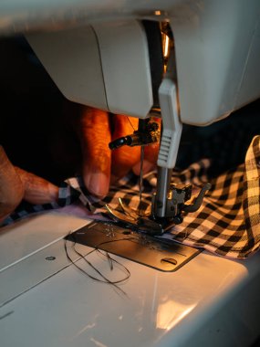 Elektrikli dikiş makinesi olan yaşlı kadın el dikme makinesi. Kıdemli İşçi ve El Sanatları.