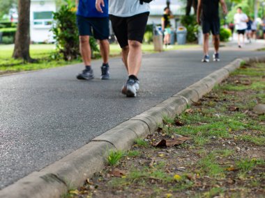 Park Yolu 'nda Yürüyen Koşucular ve Yürüyenlerle Yakın Çekim Beton Kaldırım - Kentsel Fitness Perspektifi.