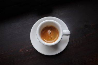 Ahşap arka planda latte sanatıyla bir fincan kahve.