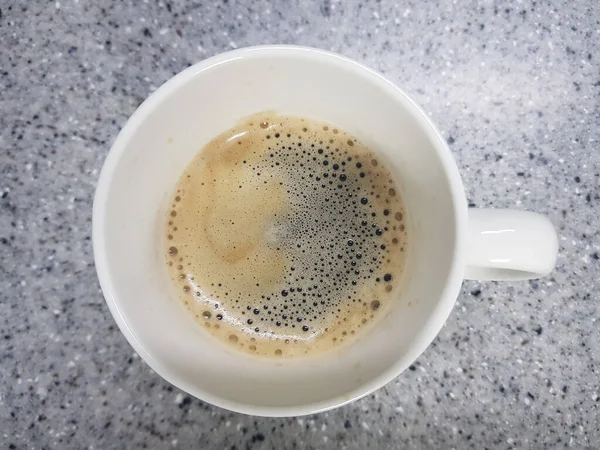 Ahşap arka planda latte sanatıyla bir fincan kahve.