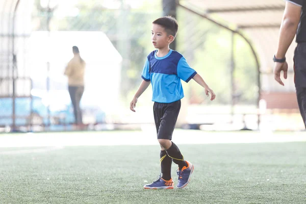 年轻亚洲足球运动员在蓝色球衣在竞争之间 — 图库照片