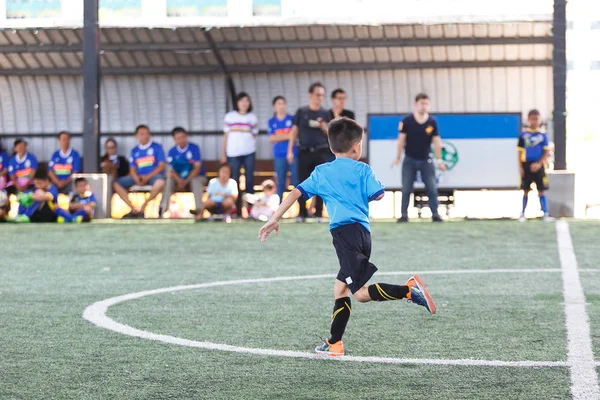 年轻亚洲足球运动员在蓝色球衣在竞争之间 — 图库照片
