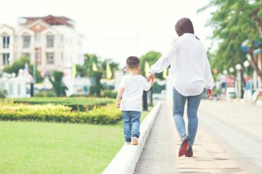 Anne ve oğlu el ele birlikte hafta sonu itibariyle parkta yürüyüş arasında almak.