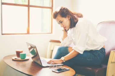 Dizüstü bilgisayar ile işini kafede çalışan yaratıcı kadın.