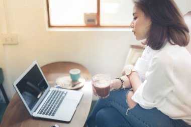 Dizüstü bilgisayar ile işini kafede çalışan yaratıcı kadın.